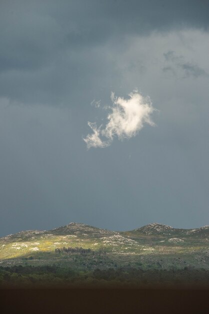 Nube aislada iluminada por el sol en medio de la tormenta