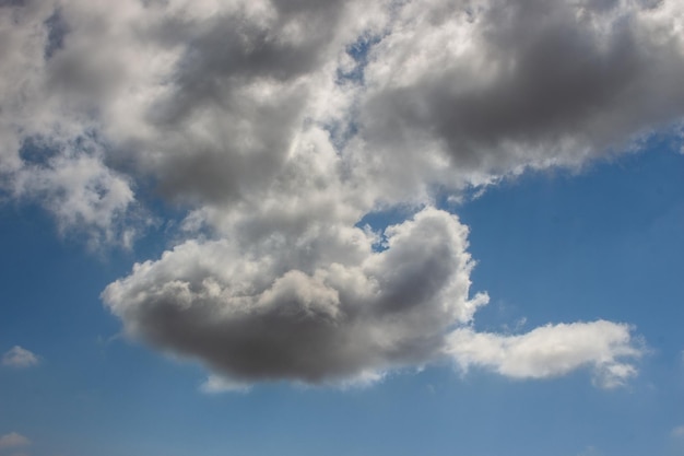 Nube de algodon gris amenazante de lluvia sobre cielo azul