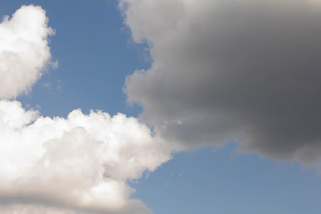 Una nube blanca una nube negra el cielo es el fondo