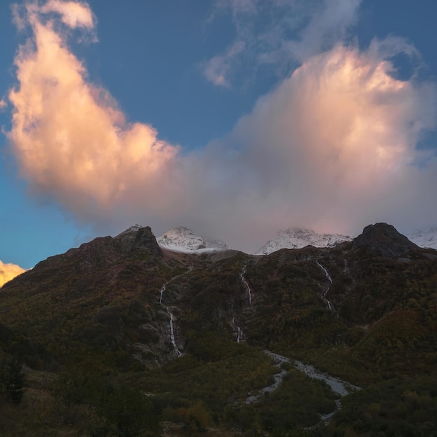 Nube coloreada sobre las montañas de la noche Nube ardiente en el eveni