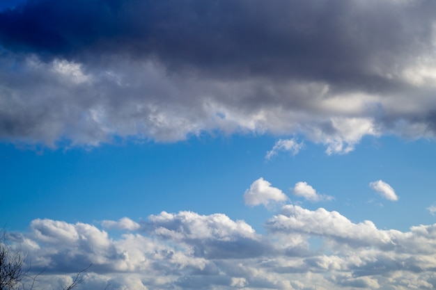 Nubes arriba y abajo y cielo azul en el medio. Día soleado de primavera. Hermosa naturaleza de fondo.