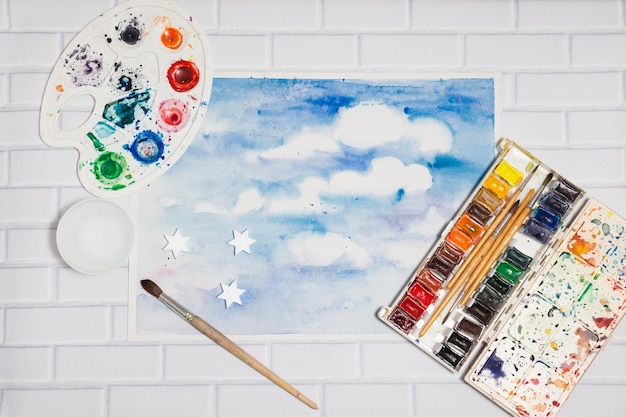 Nubes blancas Cielo azul Bosquejo dibujado a mano con pinturas, concepto de creatividad humana, vista plana superior