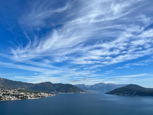 Nubes blancas en el cielo azul sobre una cordillera cerca del mar