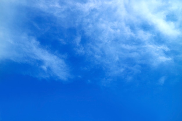 Nubes blancas y plumosas se extienden sobre un cielo azul vibrante