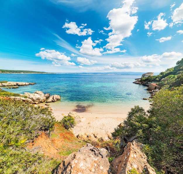 Nubes blancas sobre una pequeña cala en Alghero Cerdeña