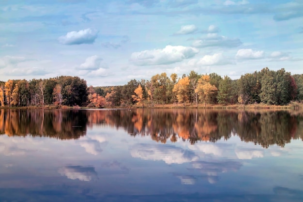 Nubes del bosque de otoño reflejadas en un lago