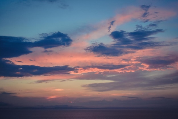 Nubes en el cielo azul durante la puesta de sol sobre el mar