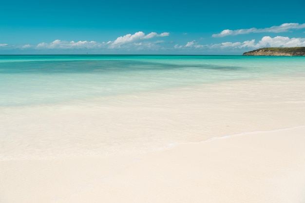 Nubes del cielo azul sobre la isla tropical de la playa del mar en calma. Playa paradisíaca tropical con arena. Los expertos en viajes revelan las mejores playas de Antigua. Arena blanca nacarada, fina como polvo. Isla del Paraiso.