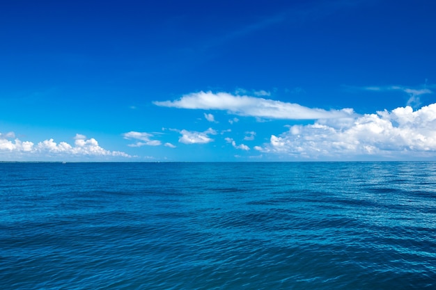 Nubes en el cielo azul sobre el mar en calma con la reflexión de la luz del sol