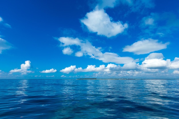 Nubes en el cielo azul sobre el mar en calma con la reflexión de la luz del sol