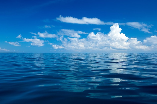 nubes en el cielo azul sobre el mar en calma con la reflexión de la luz del sol