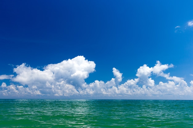 Nubes en el cielo azul sobre el mar en calma con la reflexión de la luz del sol