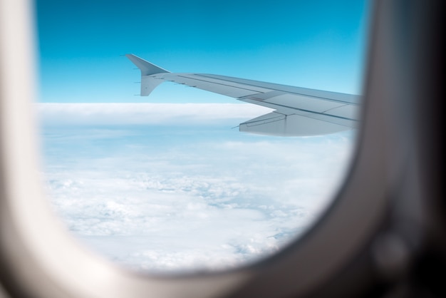 Nubes y cielo como se ve a través de la ventana de un avión.