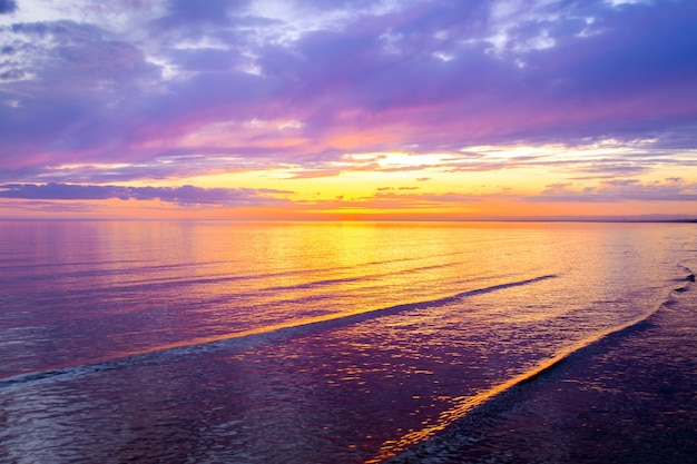 Nubes de colores en la puesta de sol, con un hermoso reflejo en el agua de mar. Vista del paisaje de verano por la noche.