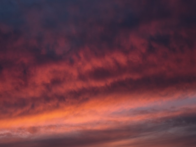 Nubes de cúmulo dramáticas rojas de la tarde en el cielo. Colorido cielo nublado al atardecer. Textura del cielo, fondo de naturaleza abstracta
