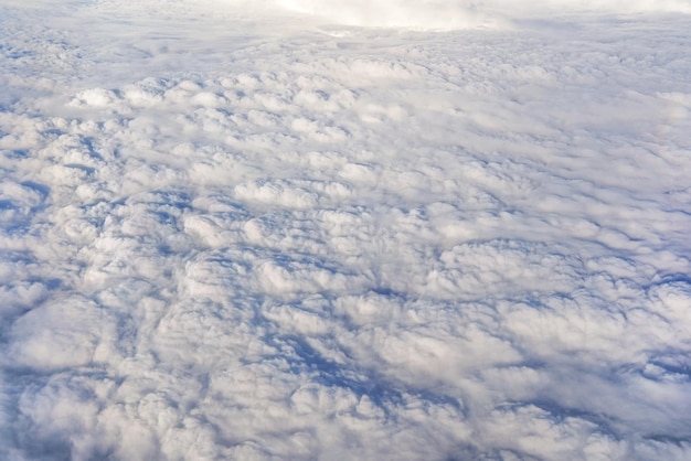 Nubes esponjosas que parecen una superficie plana como se ve desde un avión comercial