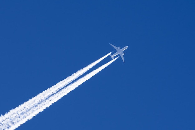 Nubes de estela de aeropuerto de aviación de dos motores de avión de pasajeros grande blanco