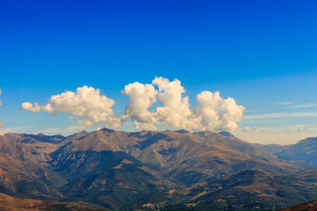 Nubes con formas curiosas en la cima de una montaña