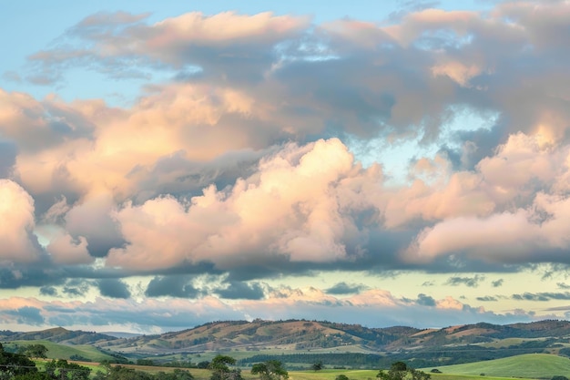 Las nubes ondulantes flotando perezosamente a través de un cielo pastel proyectando sombras calmantes sobre las colinas onduladas