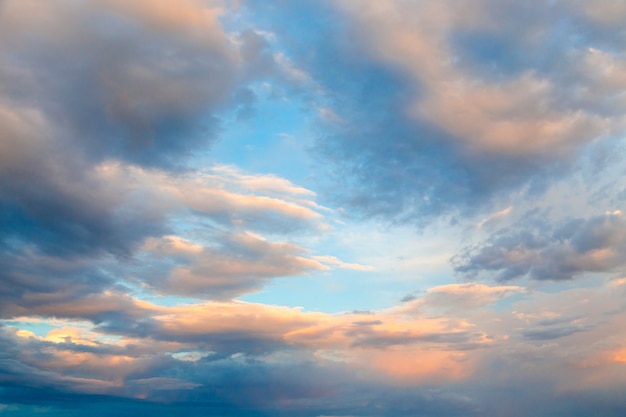 Nubes en los rayos del sol poniente contra el cielo azul