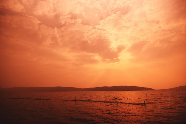 nubes rojas en el cielo en el mar con fondo de isla montañosa en el mar océano puesta de sol tropical en la playa