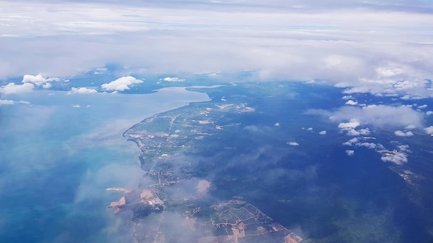 Nuboso. Vista desde el avión al mar de la ciudad y al paisaje montañoso. Enfoque selectivo.