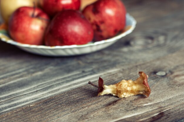 Núcleo de manzana roja comido sobre un fondo de madera