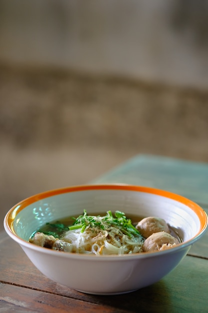 Nudel und Suppe in Schüssel auf den Tisch legen