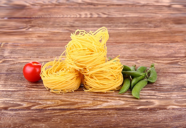 Nudeln an der Holzwand mit Tomaten, Pfeffersalat und Pfeffer