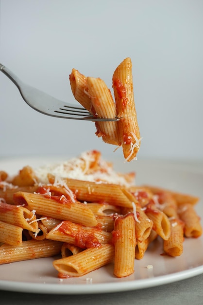 Nudeln auf einer Gabel mit Tomaten und Käse