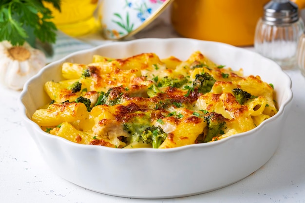 Nudeln gebacken mit Brokkoli und Hähnchen. Broccoli, Käse und Gratinsauce auf gebackenen Penne-Nudeln.