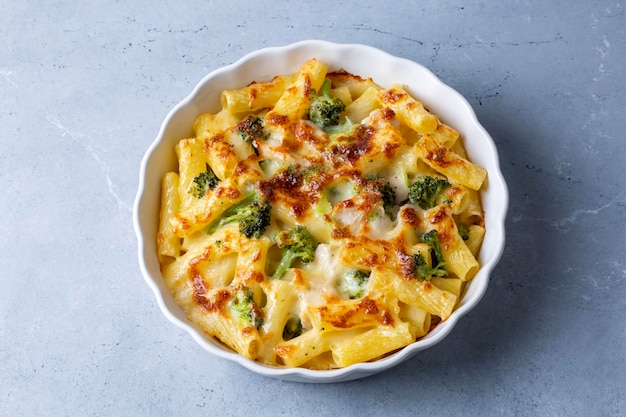 Nudeln gebacken mit Brokkoli und Hähnchen. Broccoli, Käse und Gratinsauce auf gebackenen Penne-Nudeln.