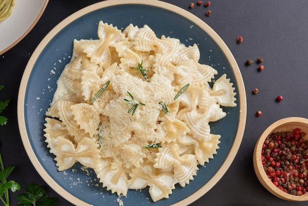 Nudeln mit grünem Gemüse und cremiger Sauce auf weißem Teller. Kopierbereich der Draufsicht. flach liegen.