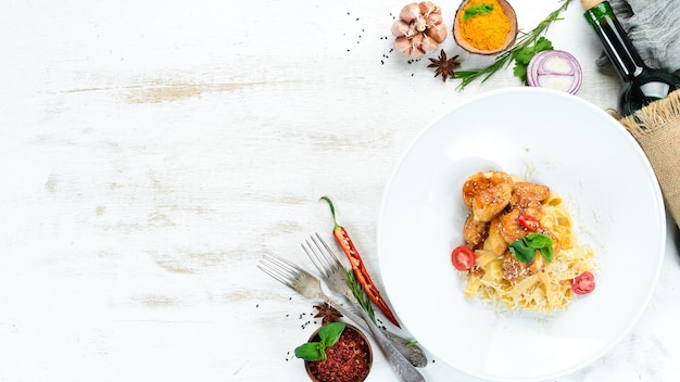 Nudeln mit Huhn und Parmesan. Auf einem hölzernen Hintergrund. Ansicht von oben. Freiraum für Ihren Text.