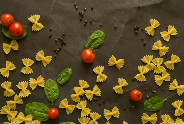 Nudeln mit Kirschtomaten und Spinat auf blachem Hintergrund flach gelegt