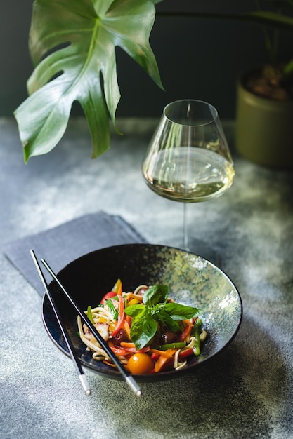 Nudeln mit Meeresfrüchten und Gemüse auf dunklem Hintergrund. Asiatisches Essen.