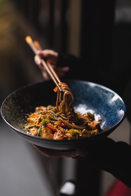 Nudeln mit Meeresfrüchten und Gemüse auf dunklem Hintergrund. asiatisches Essen