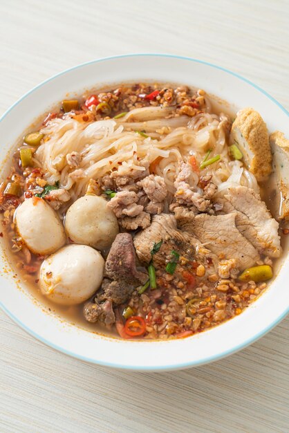 Nudeln mit Schweinefleisch und Fleischbällchen in scharfer Suppe oder Tom Yum Nudeln nach asiatischer Art