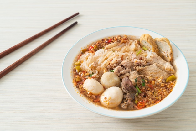 Nudeln mit Schweinefleisch und Frikadellen in scharfer Suppe oder Tom Yum Nudeln nach asiatischer Art