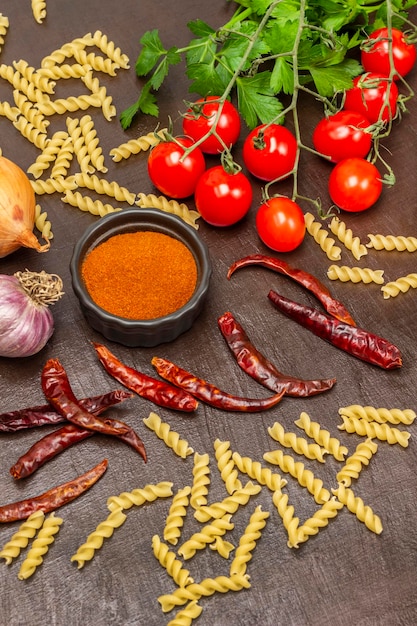 Nudeln und Pfefferschoten gemahlener Pfeffer in einer Schüssel und rote Tomaten