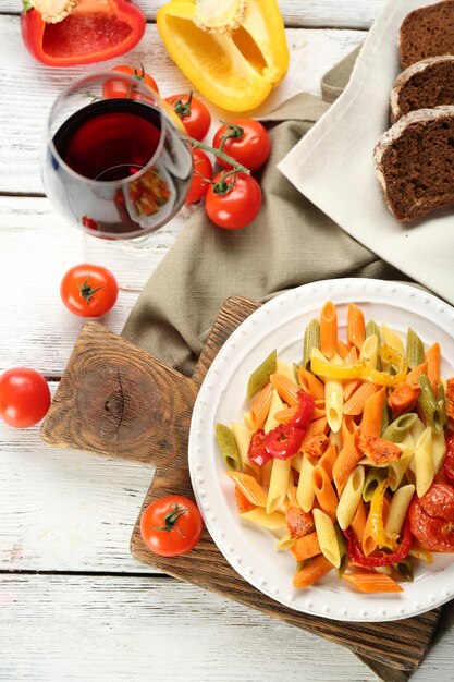 Nudelsalat mit Pfefferkarotte und Tomaten auf Holztischhintergrund