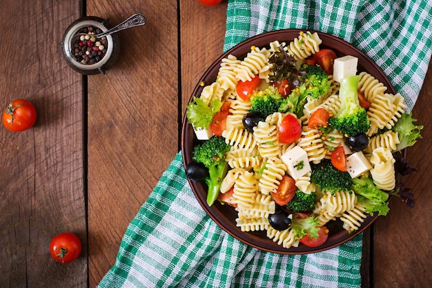 Nudelsalat mit Tomate, Brokkoli, schwarzen Oliven und Käsefeta. Draufsicht