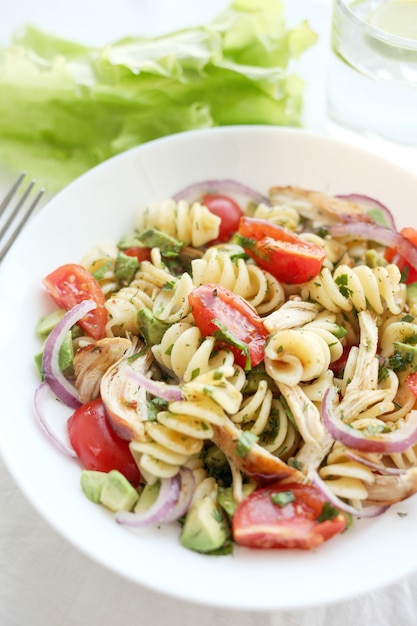 Nudelsalat mit Tomaten, Avocado, Chiken und roten Zwiebeln