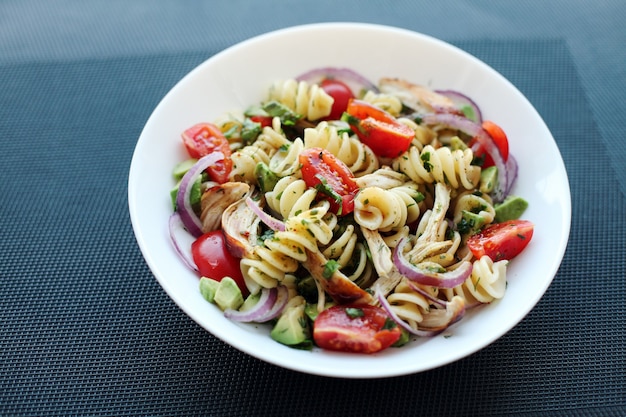 Nudelsalat mit Tomaten, Avocado, Chiken und roten Zwiebeln