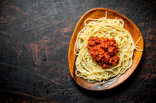 Nudelspaghetti mit Bolognese-Sauce in einer Holzschüssel