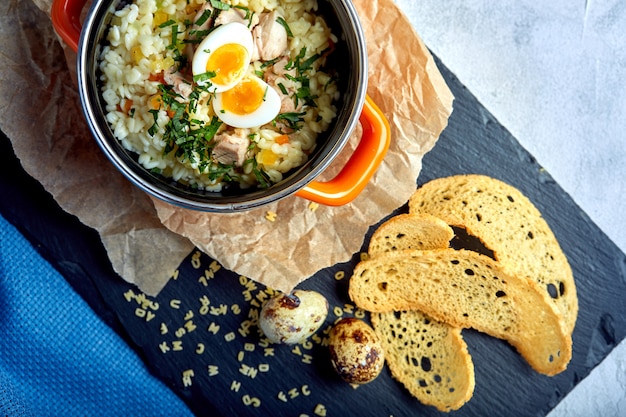 Nudelsuppe mit Ei in einem kleinen Topf kochen. Helthy Mahlzeit.