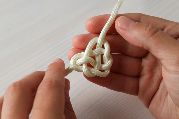 Foto nudo celta en forma de corazón hecho de cuerda blanca concepto de unidad creativa fe y protección lugar para el texto