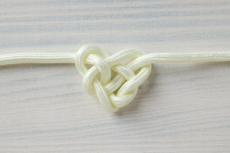 Foto nudo celta en forma de corazón hecho de cuerda blanca concepto de unidad creativa fe y protección