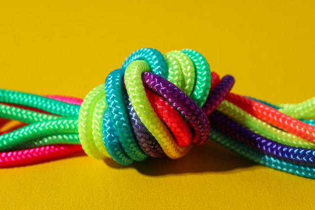 Un nudo de cordones multicolores sobre un fondo amarillo