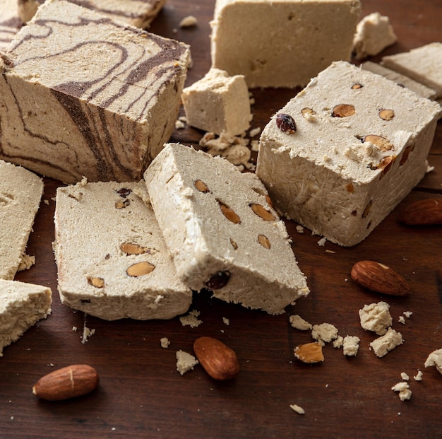 Nueces de almendra Halva y rodajas de cacao sobre fondo de mesa de madera